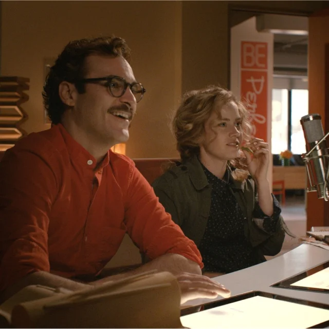 Young couple sitting and smiling, a scene from the movie “Her” from 2013